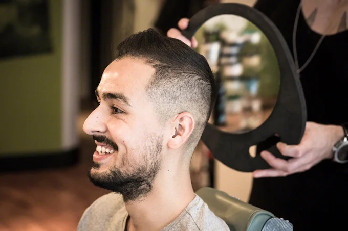 Client smiling at his fresh haircut in the mirror