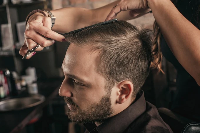 Barber scissor-cutting a client's hair