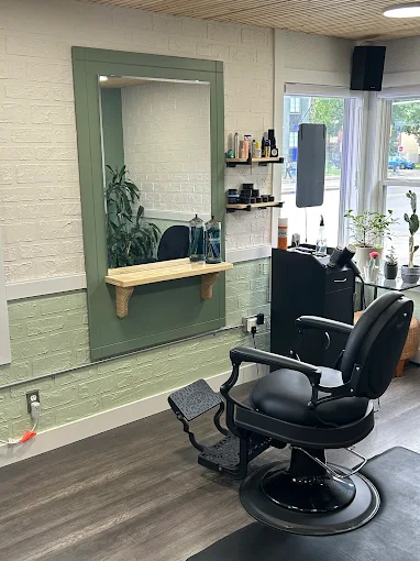 Barber chair and mirror station inside Hair We Go Again Barbershop