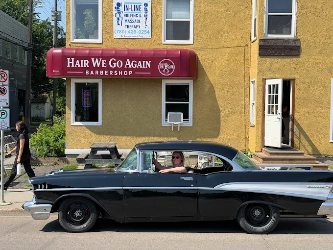 Hair We Go Again Barbershop storefront on 109 Street, Edmonton, with a classic car parked outside